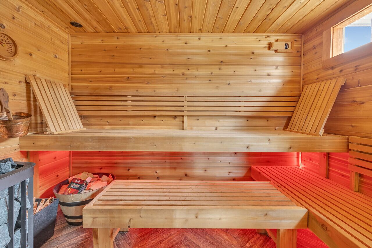 Sauna, jossa on puiset lauteet ja kiviuuni.