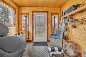 L’intérieur d’un chalet confortable, avec un canapé, un fauteuil en osier et une petite table.