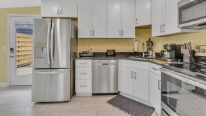 A modern kitchen with stainless steel appliances, white cabinets, and a built-in oven.