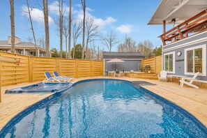 A swimming pool with lounge chairs, a wooden deck, and a covered area with tables and chairs. - Lakefront, Heated Pool, Sauna, Sleeps 8! (Lebanon)
