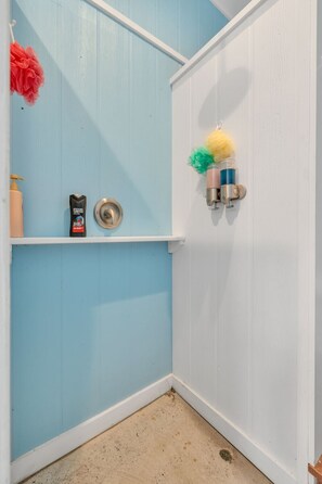 A bathroom with a blue wall, a white door, a showerhead, a soap dispenser, and a shampoo bottle. - Lakefront, Heated Pool, Sauna, Sleeps 8! (Lebanon)