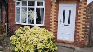 A red brick house with a white front door and a bay window. - Manchester 2-bed House, Sleeps 4, 20 Min to Centre (Manchester)