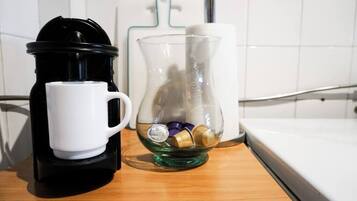 Una cafetera, una jarra de vidrio y un dispensador de toallas de papel sobre una encimera de cocina.