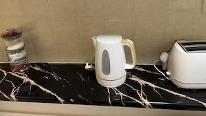A kitchen counter with a coffee maker, a jar, and a toaster. - Leicester Aprt-sleeps3-db-tv-wifi (Leicester)