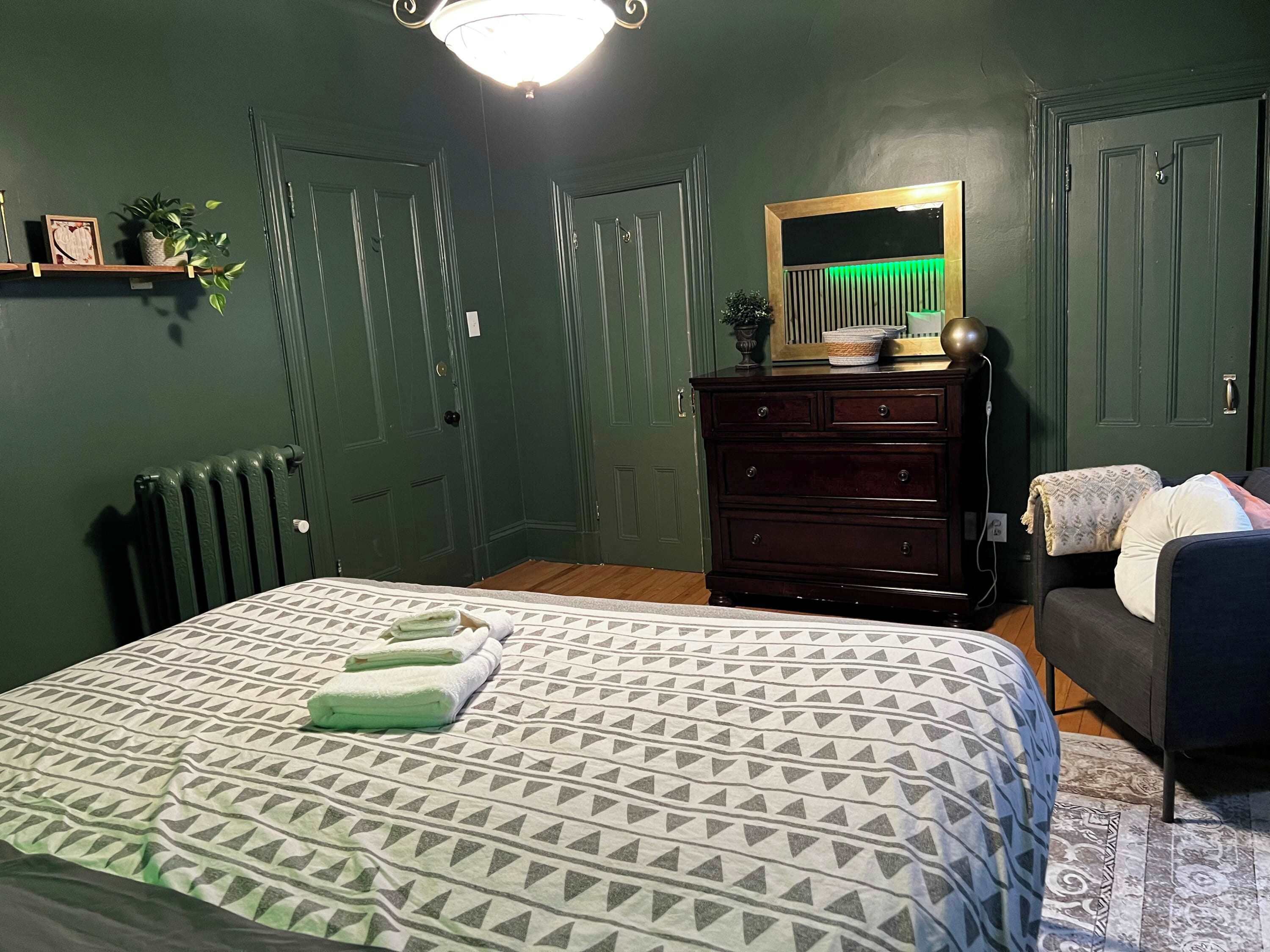 Un dormitorio con cama, cómoda y espejo.