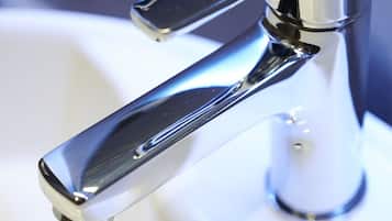 A chrome faucet with a single lever handle, attached to a white sink.