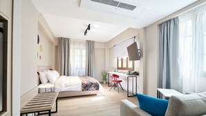 Une chambre d’hôtel moderne, équipée d’un lit, d’un bureau, d’une chaise et d’un canapé.