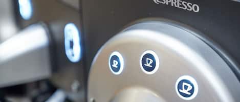 A close-up of a Nespresso coffee machine with a control panel featuring three buttons.