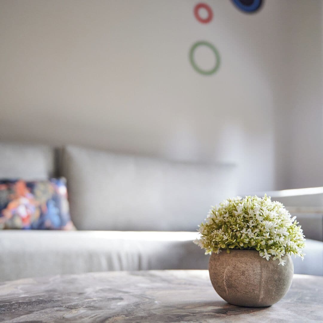 A living room with a round table, a sofa, and a decorative wall with circular ornaments.