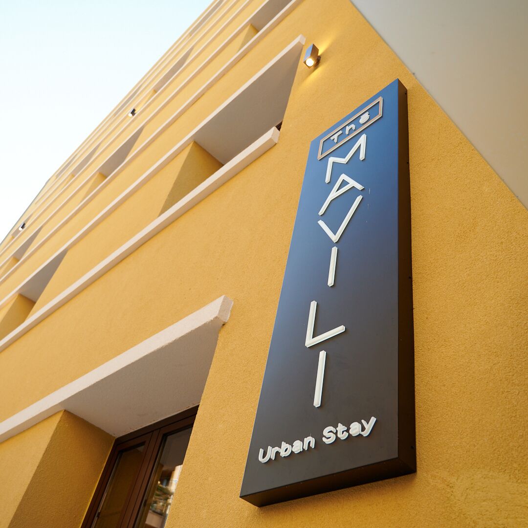 A building with a sign that reads "Urban Stay" on a yellow wall.