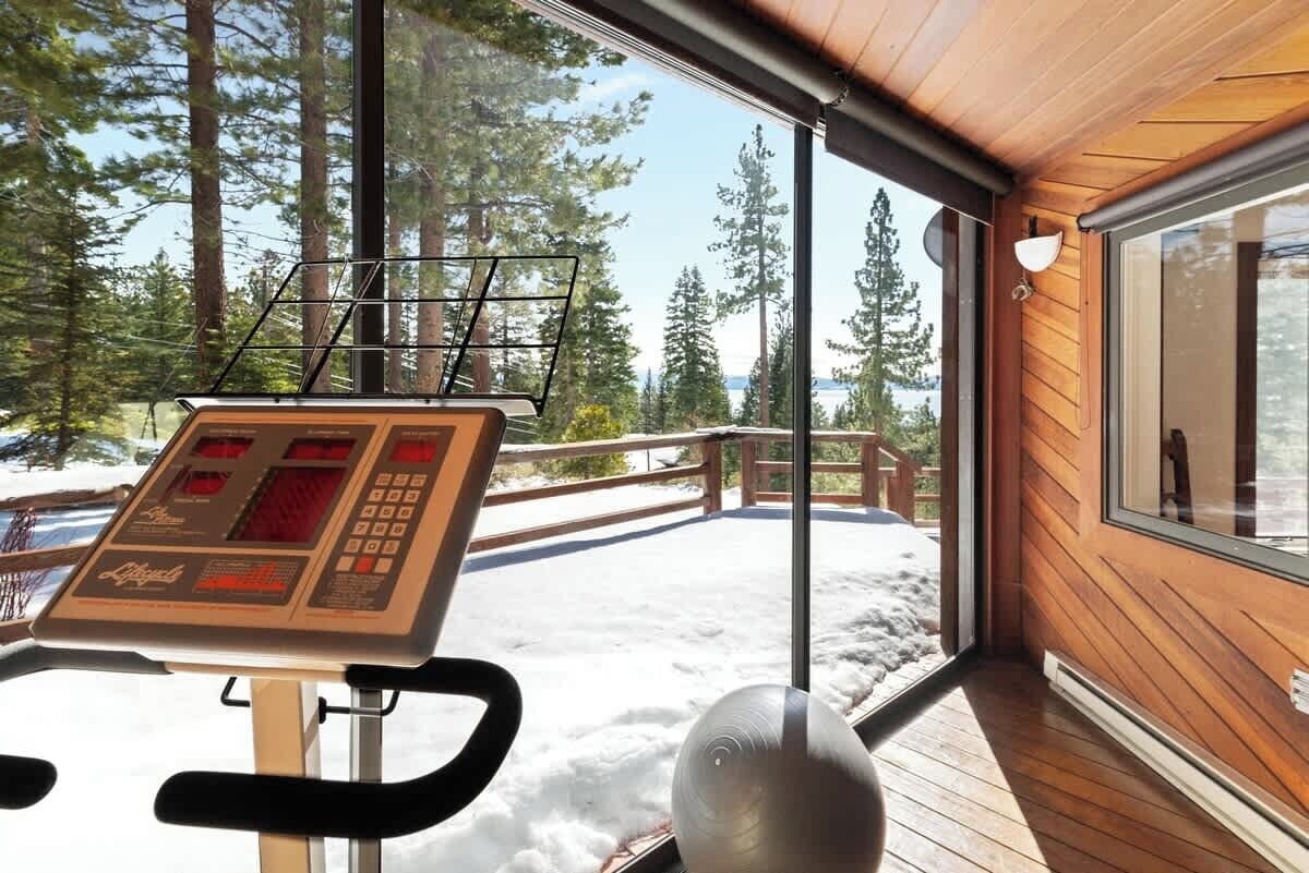 A ski lift control panel with a view of a snowy landscape and tall trees.