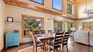 A dining area with a wooden table and chairs, a blue cabinet, and a 'JOY' sign on the wall. - Dakota Ridge (Lead)