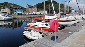 A marina with various boats docked, a stone building with a sign, and a clear blue sky. - Maison à la Mer, "Le Petit Léjon", Idéale Familles ou Amis (Plérin)