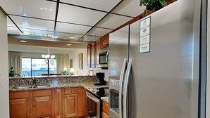 Een moderne keuken met houten kasten, roestvrijstalen apparatuur en een groot kookeiland.