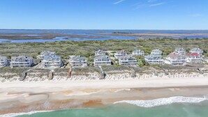 Een vogelperspectief van een kustgebied met strandwoningen, waaronder huizen en toegang tot het strand.
