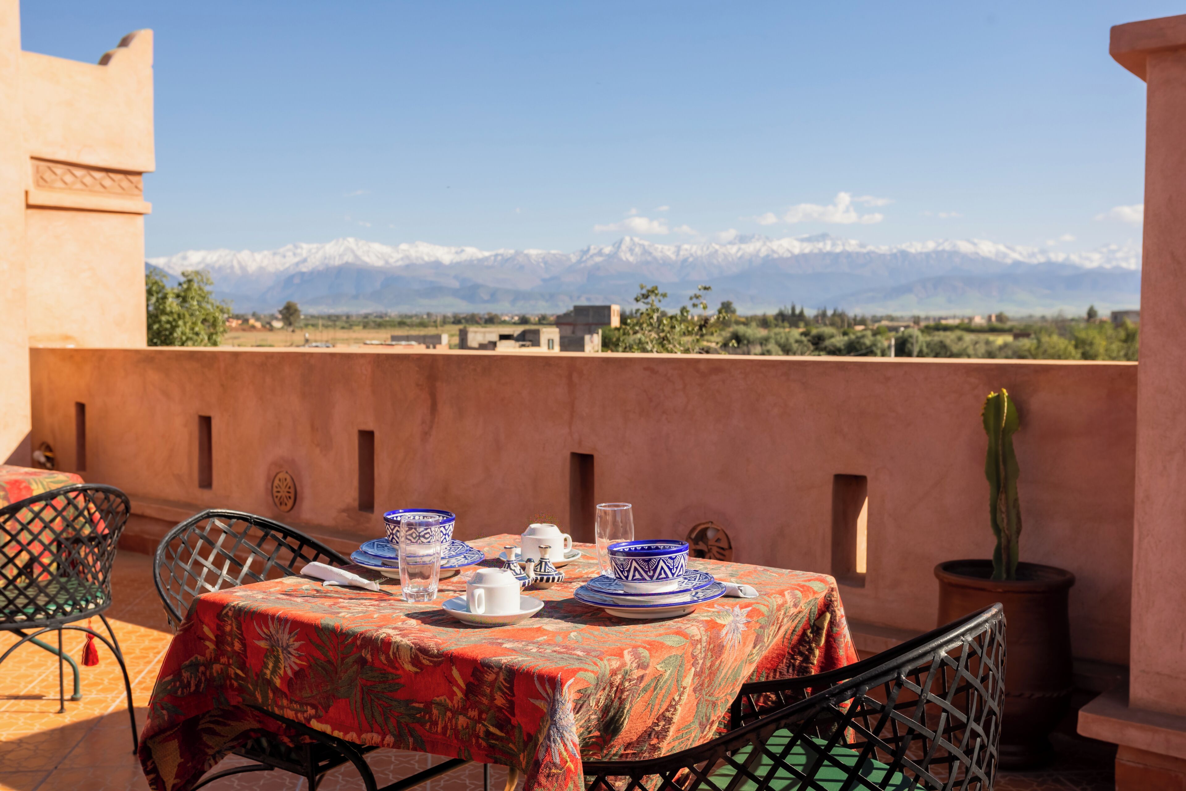 Mesa lista para comer con vistas a montañas nevadas al fondo.