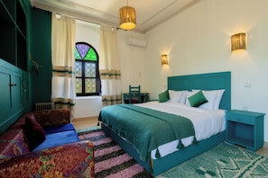 A bedroom with a bed, a nightstand, a chair, a window with curtains, and a radiator. - Riad Zinaida  (Sidi Abdallah Ghiat)