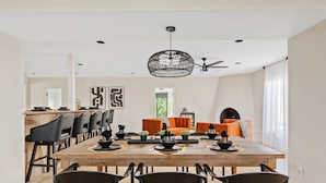 A dining area with a wooden table, black chairs, and a modern pendant light. - Desert Legacy | Scottsdale's Hidden Hideaway (Scottsdale)