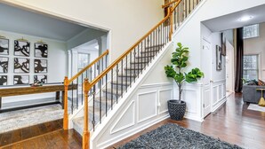 Eine Treppe mit weißen Geländern und Holzbalken, die zu einer oberen Etage führt.