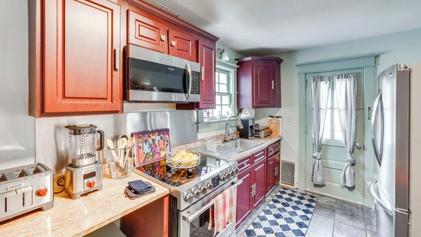 A kitchen with wooden cabinets, a microwave, a stove, and a refrigerator. - Pet-friendly Ellenville Apartment in the Catskills (Ellenville)