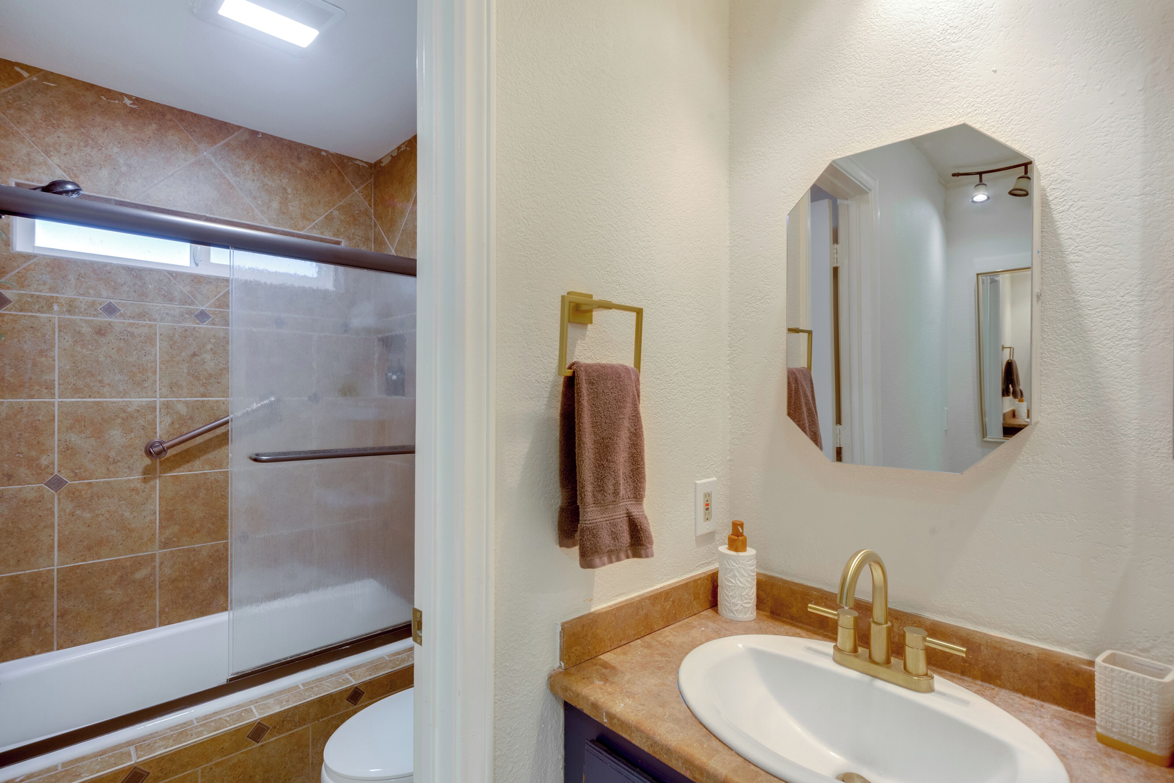 Une salle de bain équipée d’une douche, d’un lavabo, d’un porte-serviettes et d’un miroir.