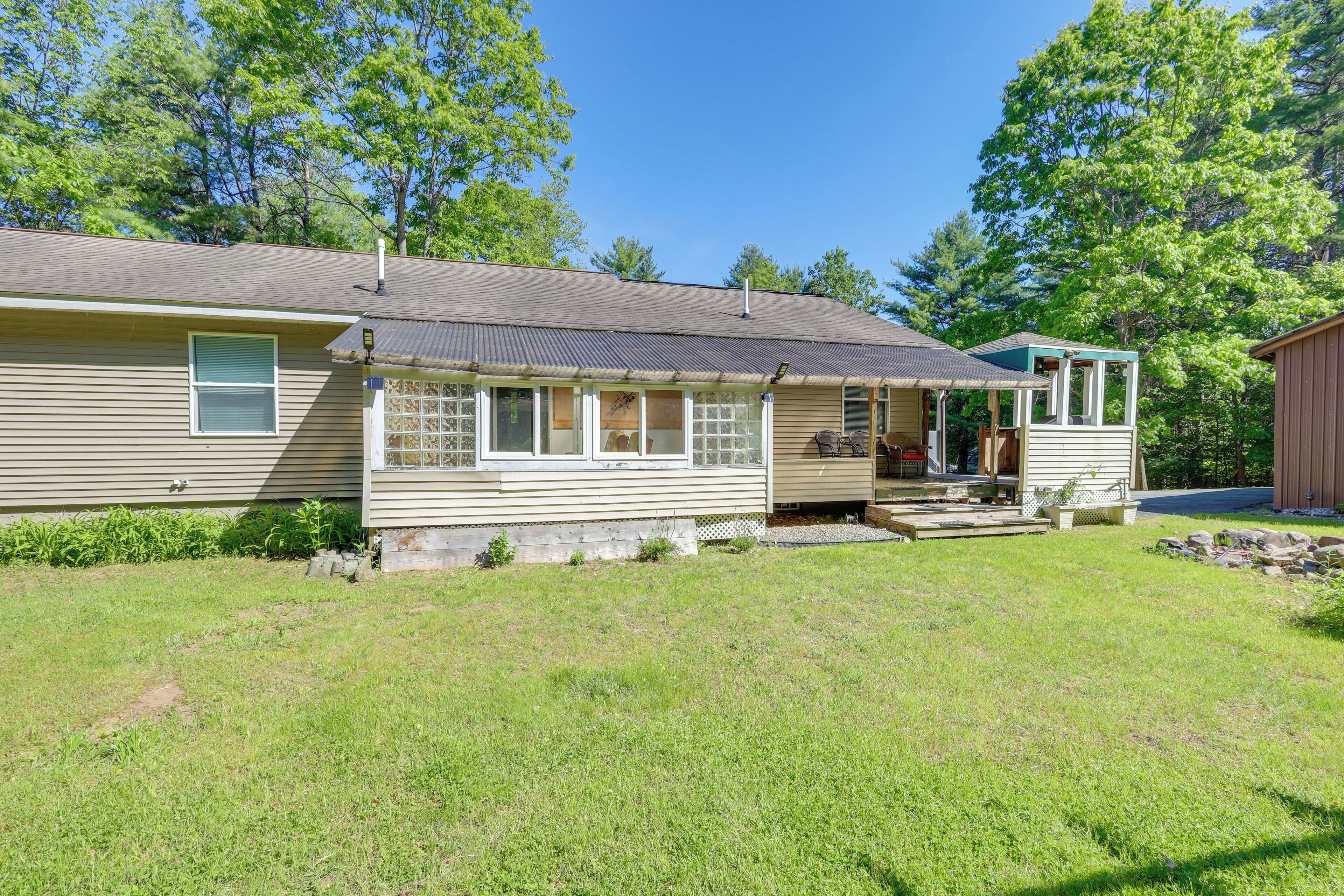 A single-story house with a front porch, a garage, and a small attached shed.