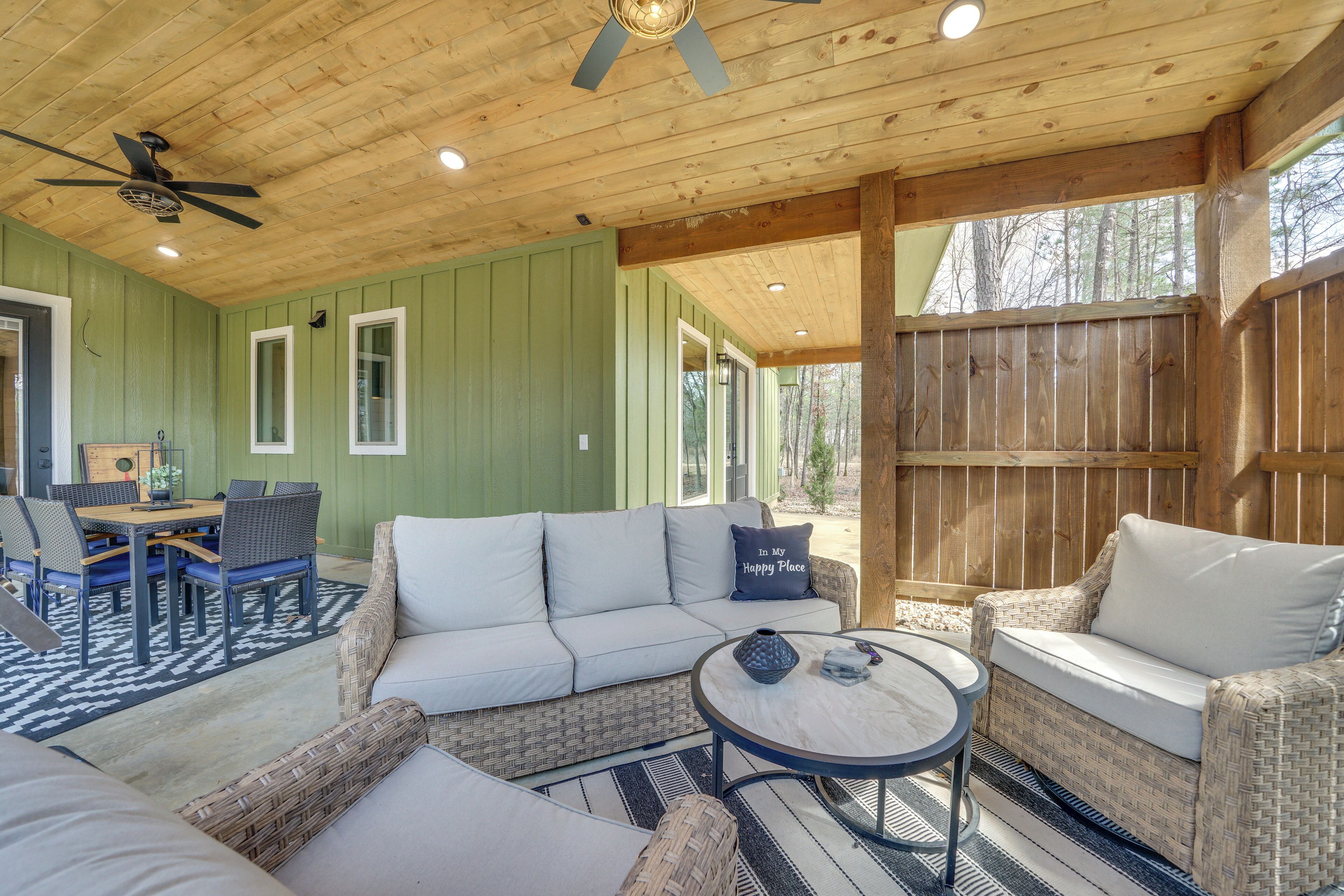 A cozy, well-lit wooden cabin with a dining area, sofa, and wicker chairs.