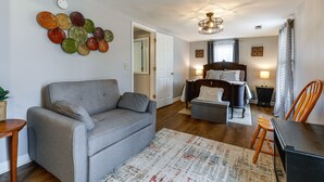 Un salon moderne avec un canapé gris, une table basse en bois et un tapis à motifs.