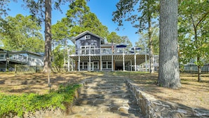 A two-story building with a balcony and a stone staircase leading to the entrance. - Hot Springs Lakefront Home w/ Dock & Water Views! (Hot Springs)