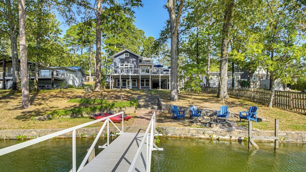 A lakeside property with a dock, a house, and outdoor seating. - Hot Springs Lakefront Home w/ Dock & Water Views! (Hot Springs)