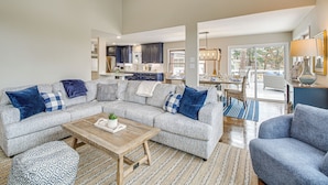 A spacious living room with a grey sectional sofa, a wooden coffee table, and patterned rugs. - Hot Springs Lakefront Home w/ Dock & Water Views! (Hot Springs)