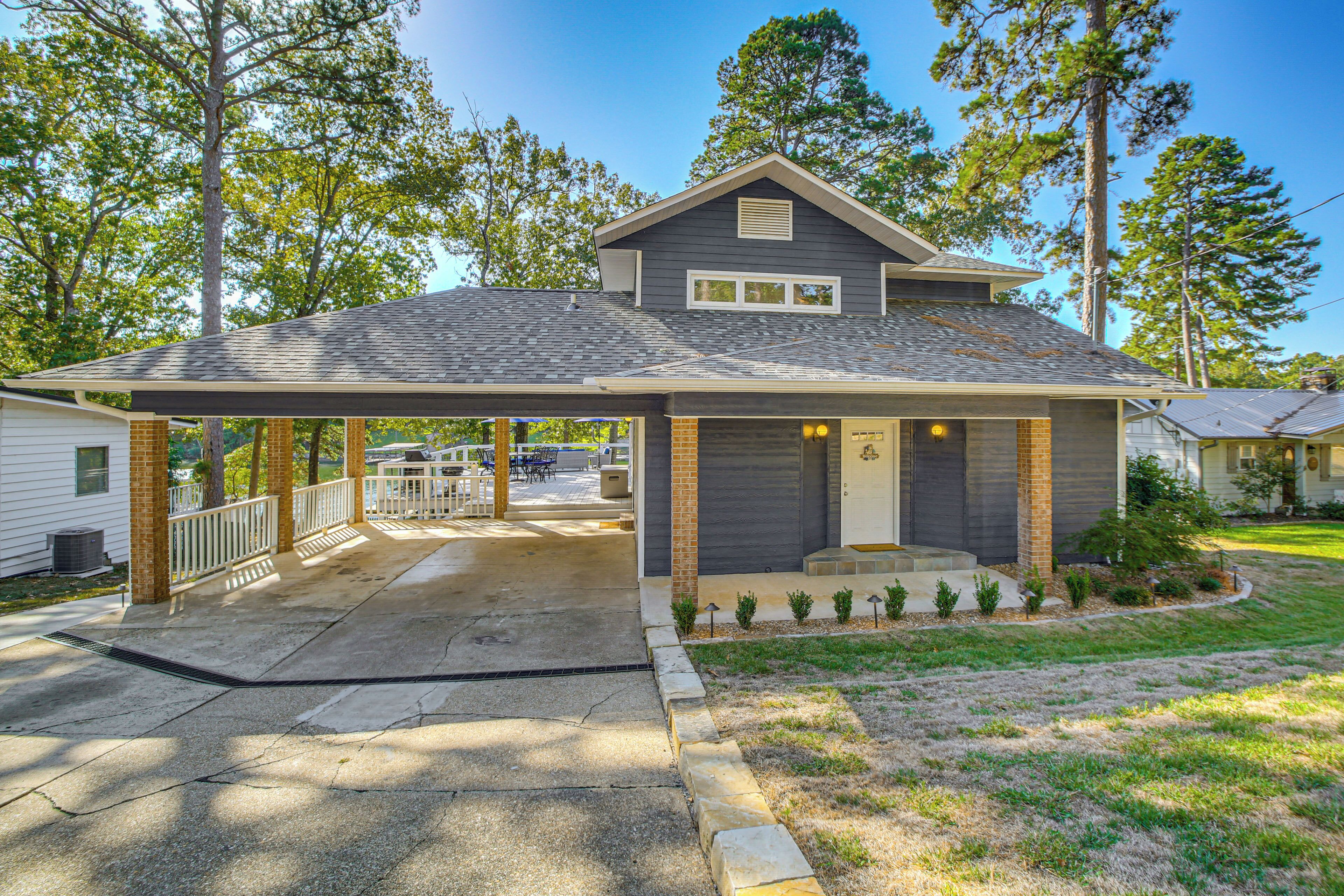 A two-story house with a covered porch, a garage, and a small front yard with young trees.
