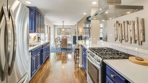 A modern kitchen with stainless steel appliances, wooden flooring, and a central island. - Hot Springs Lakefront Home w/ Dock & Water Views! (Hot Springs)