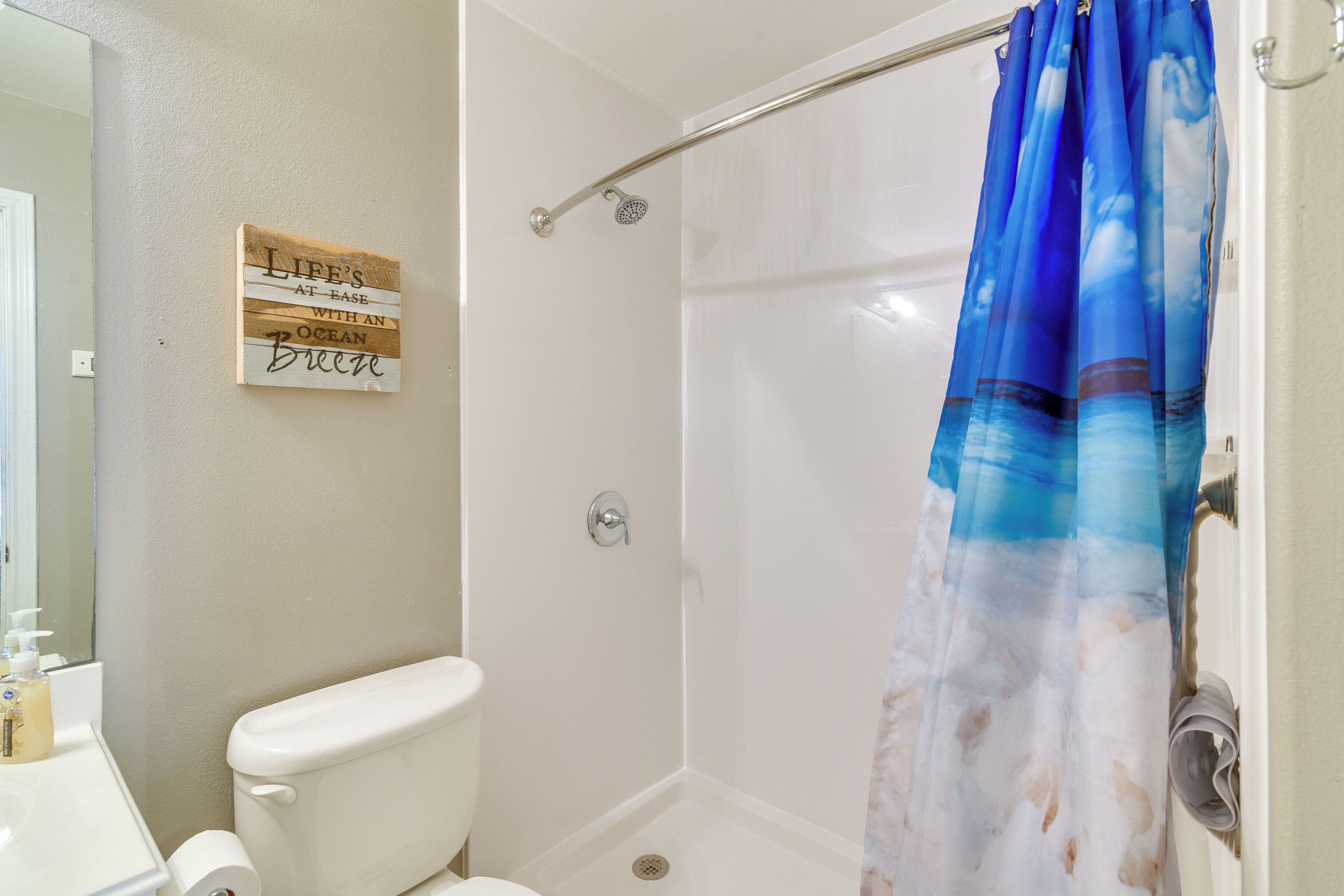 A bathroom with a shower, toilet, and sink.
