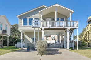 A two-story house with a balcony, a front porch, and a staircase leading to the second floor. - Galveston Getaway: Spacious Home < 1 Mi to Beaches (Galveston)
