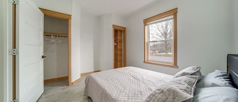 A bedroom with a bed, a window, and a closet.