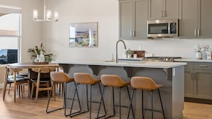 A modern kitchen with a central island, bar stools, and stainless steel appliances. - Crown Point: Ping Pong, Foosball, Hot Tub, Community Pools (Washington)