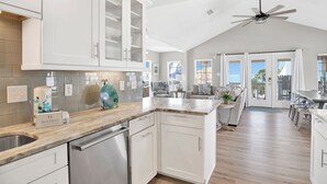 A spacious kitchen with white cabinetry, a marble countertop, and a ceiling fan. - Pet Friendly | Gulf Views | Golf Cart | Deeded Beach Access (Gulf Shores)