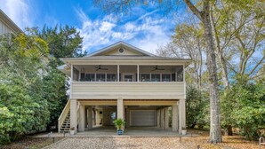 A two-story house with a covered garage and a balcony. - Five Bedroom, Four and Half Bath, Channel front, and Private Pool (Murrells Inlet)