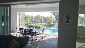 Eine Terrasse mit Pool, Gartenmöbeln und Blick auf eine Wohngegend.