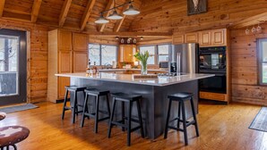 A spacious kitchen with a large island, wooden cabinets, and modern appliances.