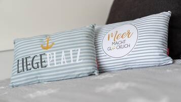 Two pillows with striped patterns and text on a bed.