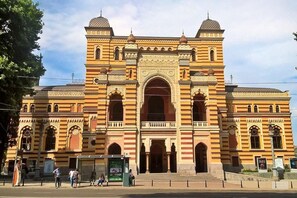 Um edifício grande e ornamentado, com um arco central e duas cúpulas menores de cada lado.