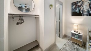 Une salle de bain avec un miroir, un porte-serviettes, une douche et une table de chevet avec une lampe.