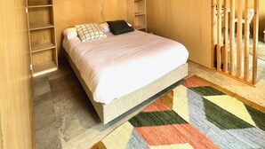 Une pièce en bois avec un lit, des étagères et un luminaire suspendu.