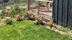 Une terrasse en bois offrant une vue sur une vallée et des montagnes.