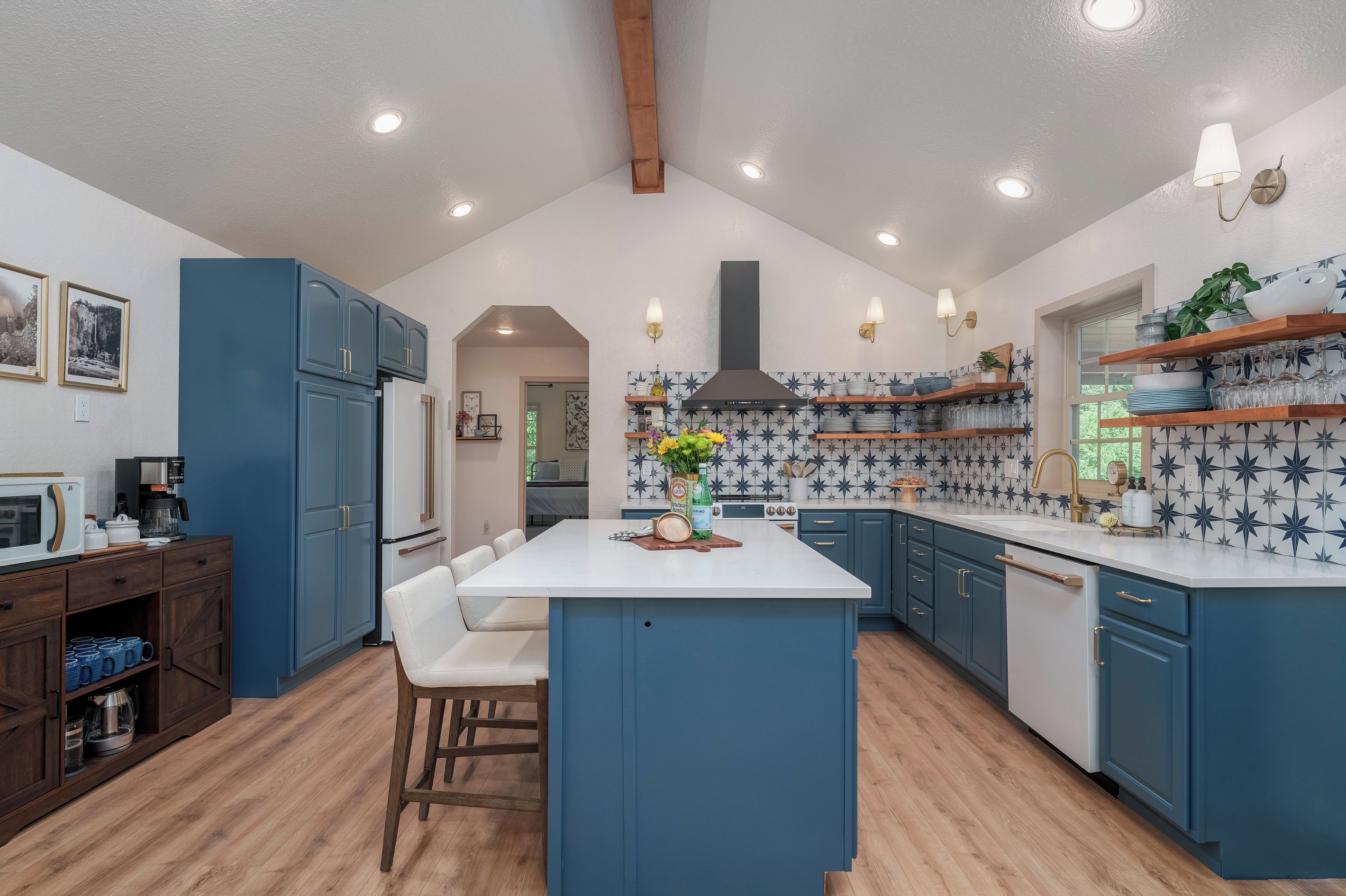 Spread out in a kitchen built for a crowd: Café range, quartz counters, open shelving and seats at the island, steps from the deck over the river.