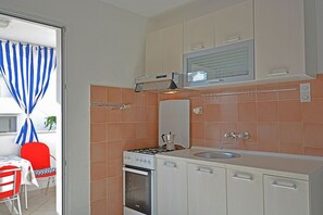 Enjoy cooking in this kitchen with a stainless steel stove, microwave, and sink with a faucet, adjacent to a dining area.