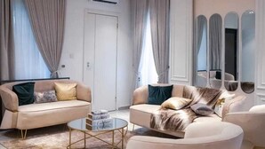 Een moderne woonkamer met twee banken, een salontafel en een grote spiegel.