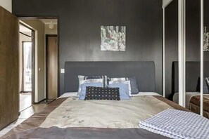 A bedroom with a large bed, a headboard, and a painting on the wall. - Karlstad Unic House Kronoparken (Karlstad)